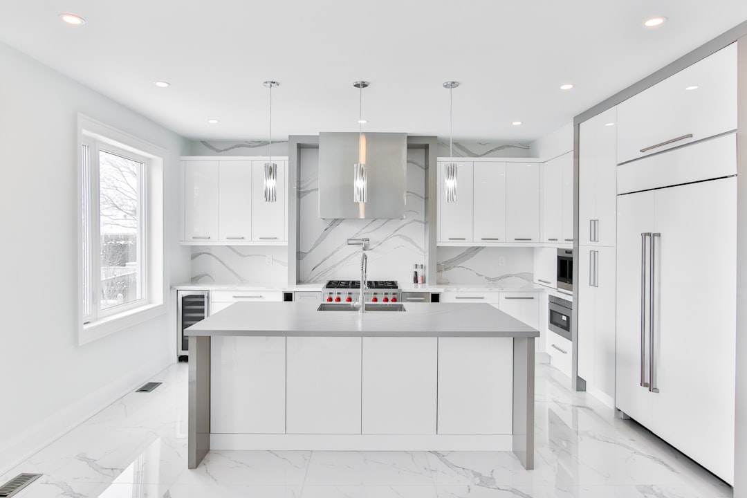 White modern kitchen in Singapore home with clean counters and bright lighting.